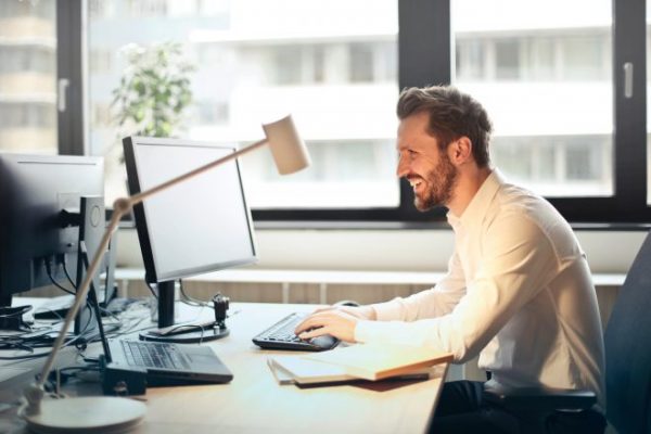 Office worker sitting at desk thinking about ergonomics