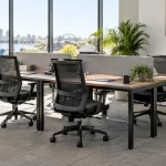 Oak-look workstations and black mesh chairs in a bright Australian office.