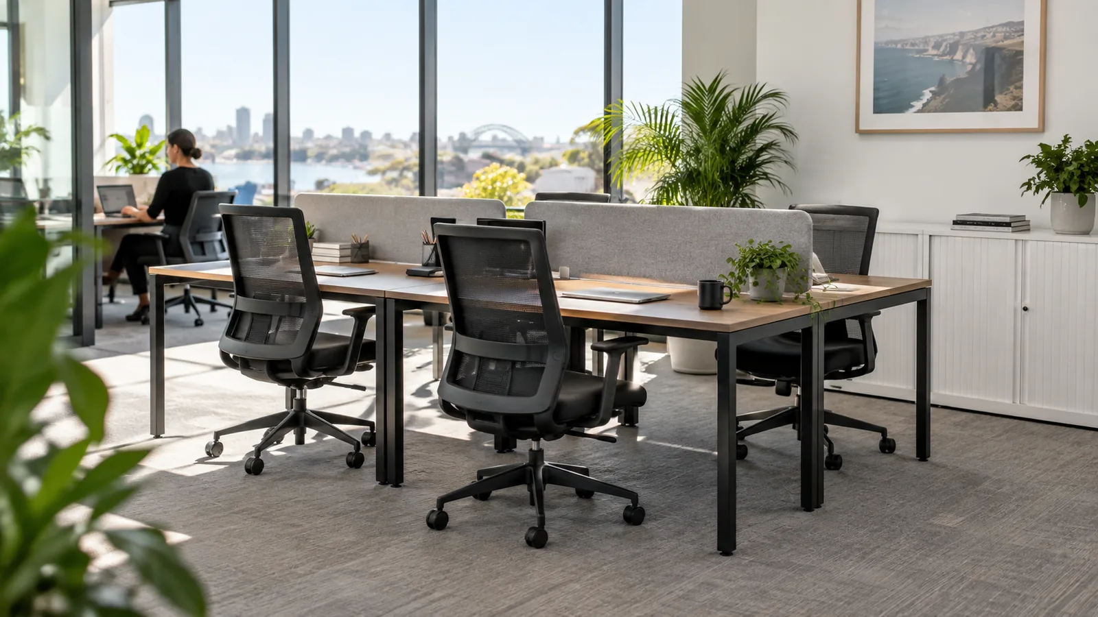 Oak-look workstations and black mesh chairs in a bright Australian office.