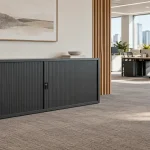 Charcoal tambour cupboard beside a clear access area in a modern office.